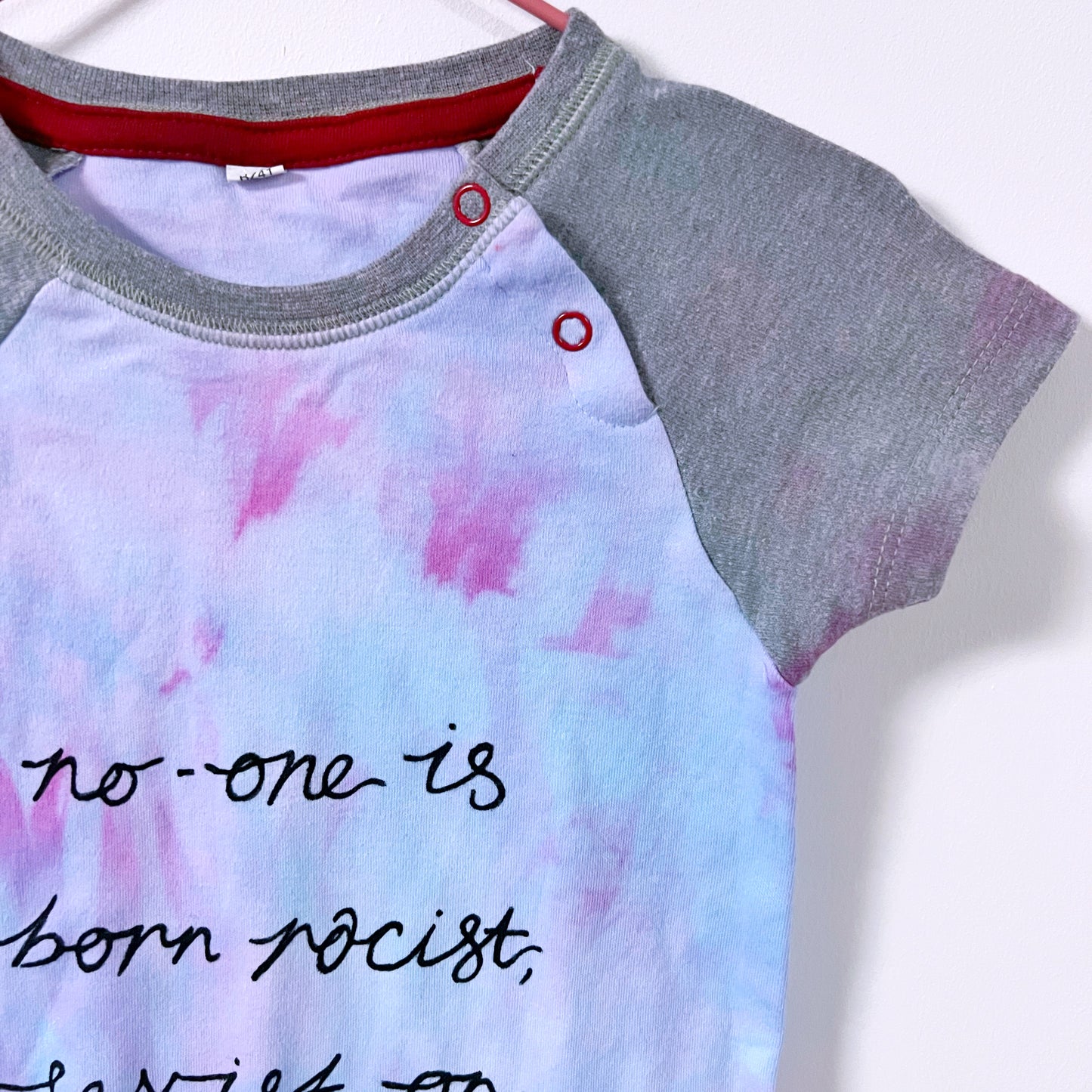 hate is taught tie dye baby bodysuit