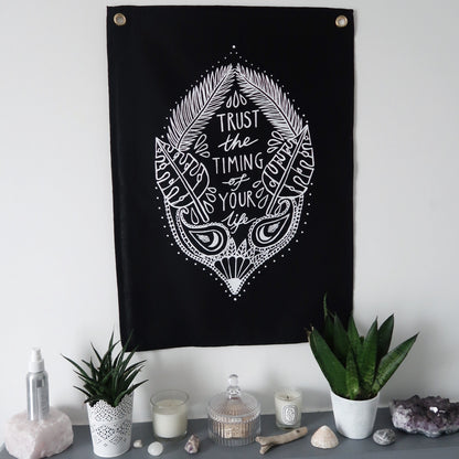 trust the timing of your life wall hanging - black
