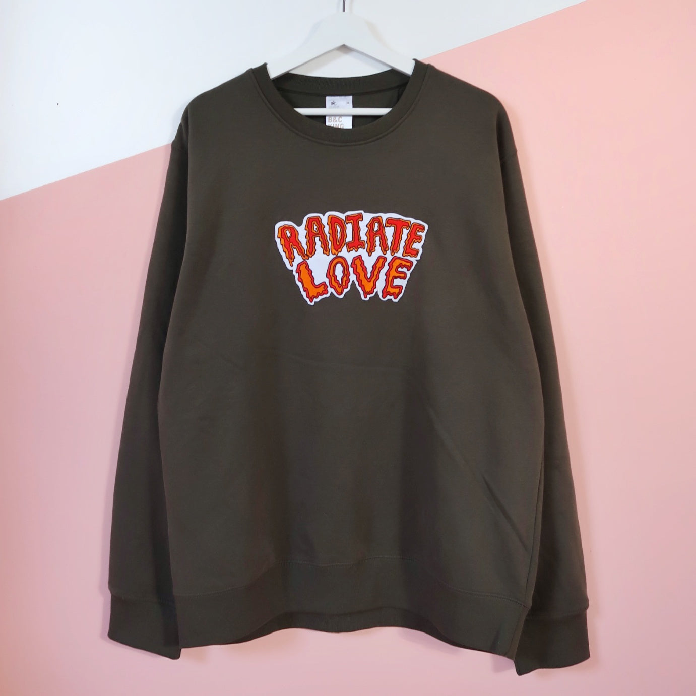 the khaki green Radiate Love sweatshirt - as worn by Ariana Grande.